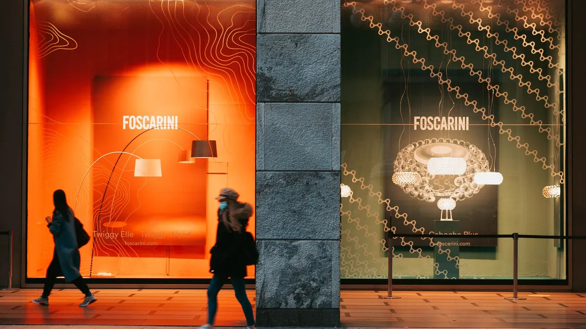 Commercianti che osservano il flusso dei clienti in una via dello shopping italiana